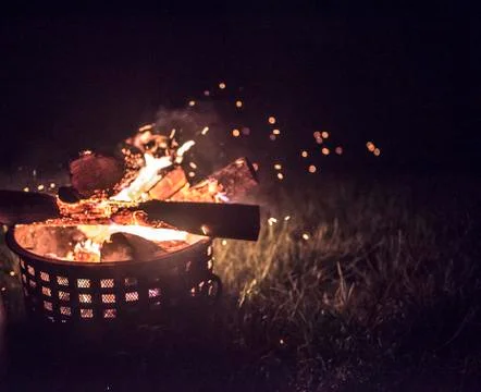 Outside fire inside of a fireproof canister on grass Stock Photos