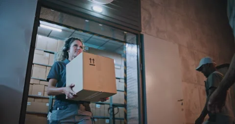 Outside of Logistics Retail Warehouse at Night: Female Worker Giving Cardboard Vídeo Stock 313343433