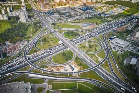 Outside look on intersection. Traffic, residential area and green forest arou Stock Photos