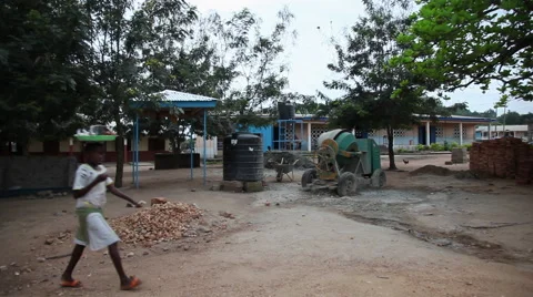 OUTSIDE PAKRO SCHOOL: CEMENT MIXER AND POLYTANKS Stock Footage 59734833