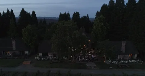 Outside party event by fields at evening dusk. Drone aerial B Stock Footage 111650468