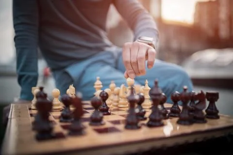 Outside picture of man that keep chess pawn on board Stock Photos