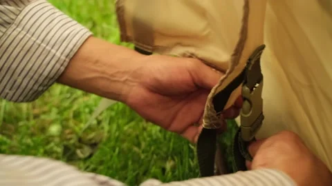 Outside the tent threads the belt, fastens the buckle, tightens and straightens Stock Footage 249210205