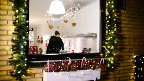 Outside view of christmas cooking in a kitchen where woman prepares food Stock Footage 99721824