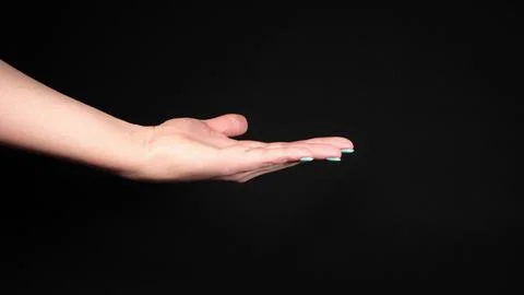 An outstretched female hand on a dark background Stock Photos