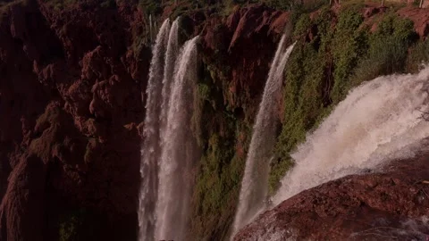 Ouzoud Falls streaming down red rocky cliffs in Morocco Atlas Mountains 库存影片 334694507