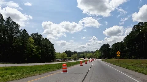 OV driving through construction zone orange and white pylon markers Stock Footage 179957345
