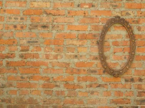 Oval bronze frame on the background of an old brick wall. Foto stock