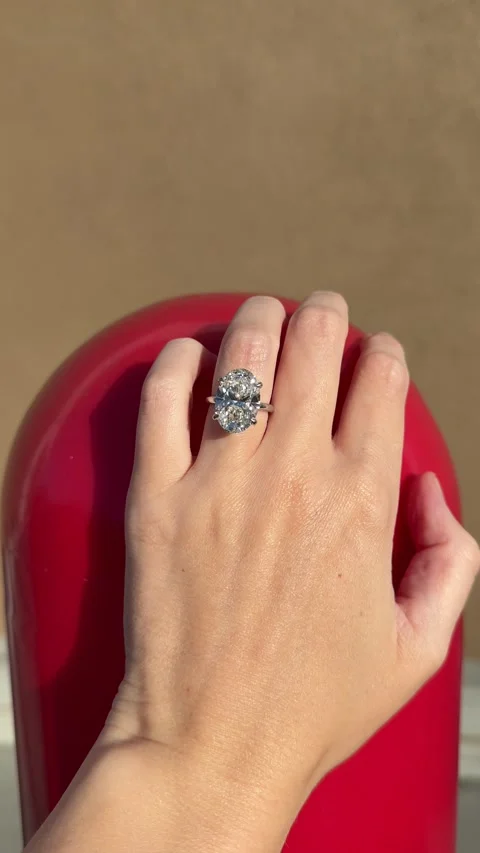 Oval diamond engagement ring reflecting light against red painted pole Stock Footage 320313937