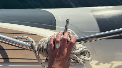 Oval diamond ring hand resting on yacht against stunning sea horizon Stock Footage 319406923