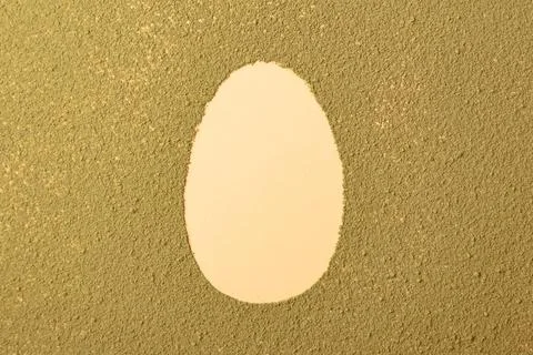 Oval easter egg silhouette made from matcha tea on green textured background Stock Photos