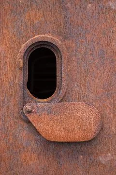 Oval rusty closed hatch on the surface  of a destroyed airborne amphibious Stock Photos
