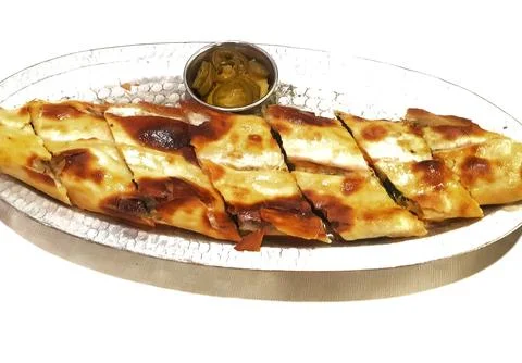 Oval shaped pide bread, sliced and served with pickled peppers, offers an aut Stock Photos