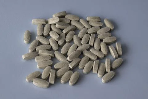 The oval vitamins fall on a blue background. Multivitamin complex for health Stock Photos