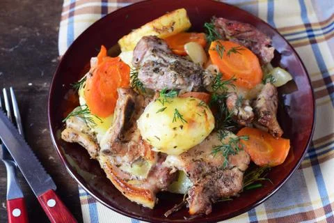 Oven cooked pork with potato, carrots and onion in olive oil and spices Stock Photos