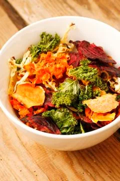 Oven cooked vegetable chips with lettuce, potatoes, basil and herbs Stock Photos