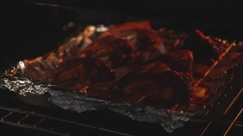 Oven door open with marinated chicken wings roasting on foil Stock Footage 312647858