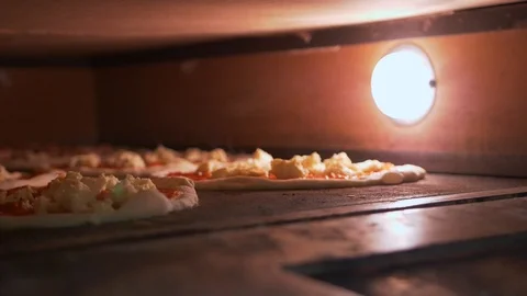 The oven, inside which burns light and bakes several circles of pizza. Stock Footage 104866597