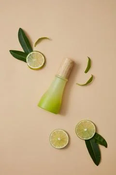Over a beige background, a gradient green bottle is decorated with few round  Foto stock