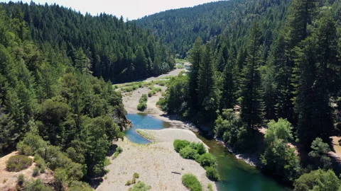 Over a bridge following a river through mountain forest1 Stock Footage 152862403