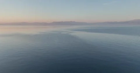 Over the calm sea surface during the nightfall Stock Footage 253109680