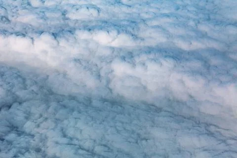 Over a continuous rippled cloud layer stretching Stock Photos