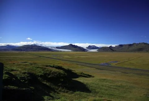 Over the green fields to the glacier Stock Photos