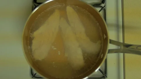 Over head shot of pot boiling frozen chicken Stock Footage 102163065