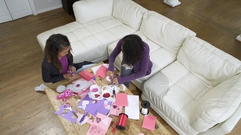 Over head view of two girls craft making together at table. Stock Footage 88174977