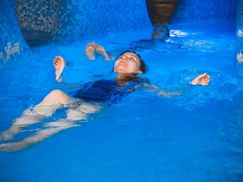 Over head view of two young women floating in water and laughing, full frame. Stock Photos