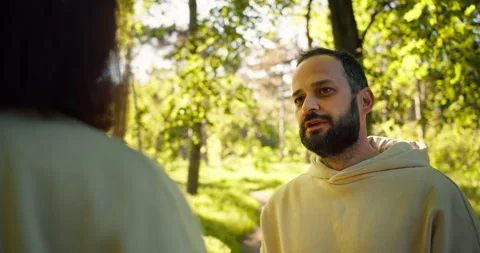 Over his shoulder a brunette guy with a beard in a yellow hoodie talks to his Stock Footage 280617486
