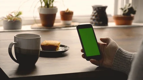 Over The Left Soulder SHot OF Man With Chroma Key Cell Phone While Having Bre Stock Footage 117692690