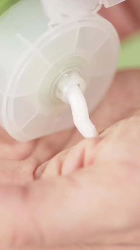 Over a light green background, a hand model squeezing cream from a tube, ma.. Stock Footage 306368286