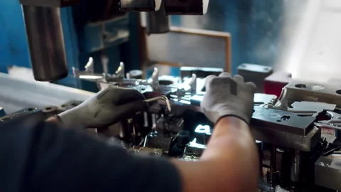 Over the shoulder angle of  a factory worker assembling a big hydraulic Stock Footage 255217968