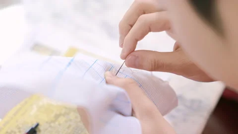 Over shoulder asian boy is making crafts cross stitch at home. Video stock 145849960