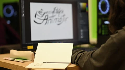 Over the shoulder classroom shot of a student sitting at a wooden desk with an Stock Footage 335252463
