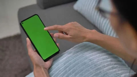 Over shoulder closeup view of asian woman user holding smart phone watching mobi Stock Footage 142457786