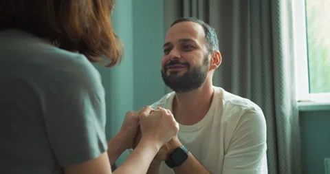 Over the shoulder a confident brunette guy with a beard holds hands with his Stock Footage 280666027