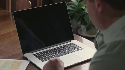 Over the shoulder cu of a man working in his laptop Stock Footage 71342851