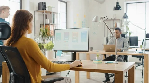 Over the Shoulder: Female Mobile Software Developer Sitting at Her Desk Using PC Stock Footage 112599222