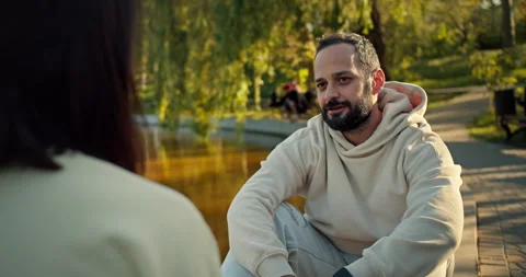 Over the shoulder a happy brunette guy with stubble in a white hoodie Stock Footage 280636017