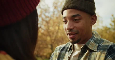 Over the shoulder a happy guy with black skin in a hat and plaid shirt Stock Footage 299924471