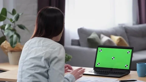 Over shoulder laptop screen view. Young woman has video call on laptop green Stock Footage 164531495