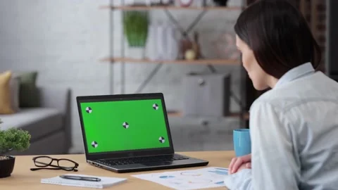 Over shoulder laptop screen view. Young woman has video call on laptop green Stock Footage 164531576