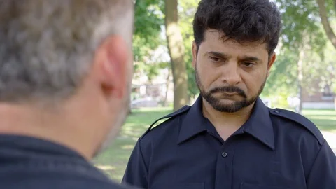 Over the Shoulder - A man is being berated by another man while outside at a Stock Footage 124718990