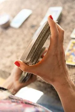 Over-the-shoulder perspective of a tarot reader skillfully mixing the tarot.. Stock Photos