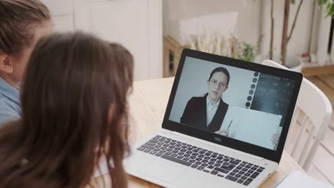 Over the shoulder shot. Children learn remotely by videoconference with the Vidéo 142937545