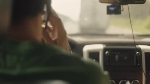 Over the shoulder shot of a driver uses cellphone while changing lanes Stock-Footage 121799071