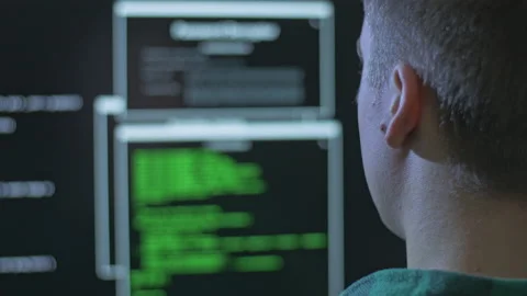 Over the shoulder shot of a hacker committing a cyber crime from home Stock Footage 142920366