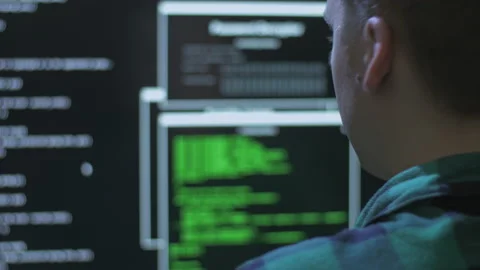 Over the shoulder shot of a hacker committing a cyber crime from home 스톡 동영상 142927498